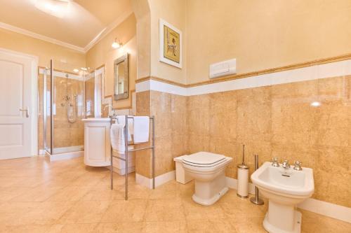 a bathroom with a toilet and a shower and a sink at Villa Ardea in Soiano del Lago