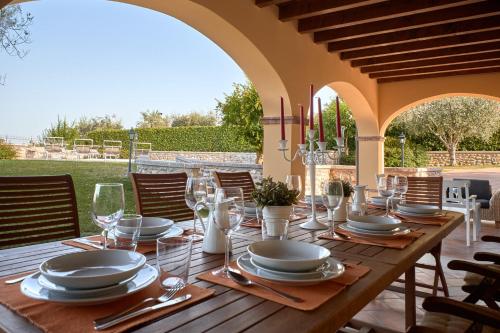 una mesa de madera con platos y copas de vino. en Villa Ardea, en Soiano del Lago