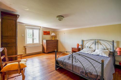 ein Schlafzimmer mit einem Bett, einem Stuhl und einem Fenster in der Unterkunft Villa Carpe Diem in Méréville