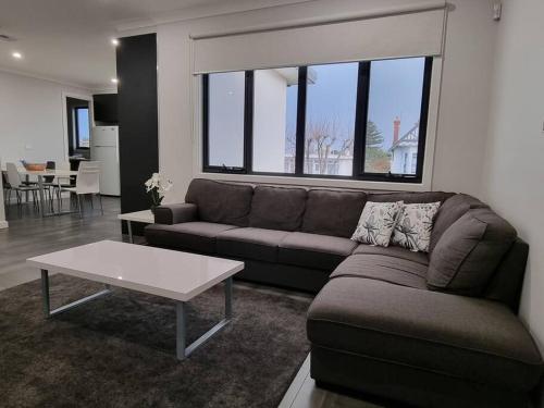 a living room with a couch and a table at Spacious Modern Apartment - St Kilda East in Melbourne