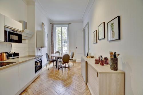 une cuisine avec une table et une salle à manger dans l'établissement L'Impérial - Luxeux appartement dans le Triangle d'Or, à Bordeaux