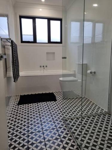 a bathroom with a glass shower and a toilet at Spacious Modern Apartment - St Kilda East in Melbourne