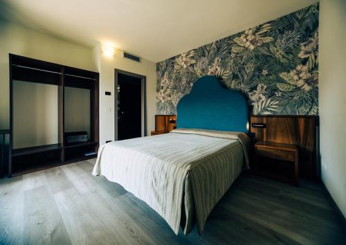 a bedroom with a large bed with a blue headboard at Continental Hotel in Lovere
