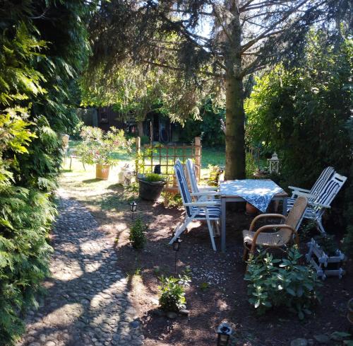 un jardin avec une table et des chaises sous un arbre dans l'établissement B&B Family Basement Apartment, Breakfast, Free Parking, 5km from Tulln, à Chorherrn