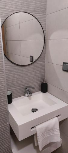 La salle de bains est pourvue d'un lavabo blanc et d'un miroir. dans l'établissement Alojamento Local - Covas, à Santiago do Cacém