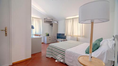 a bedroom with a bed with a lamp on it at MIIO HOTEL in San Vincenzo