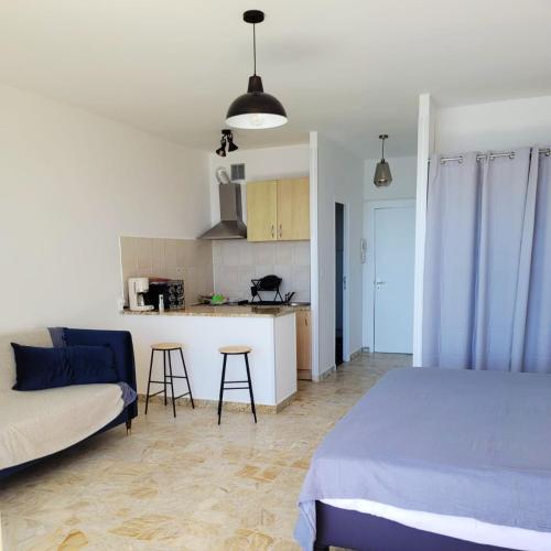 un salon avec un lit et une cuisine dans l'établissement Studio agréable avec vue mer à Ajaccio - 30 m² avec accès plage, à Ajaccio