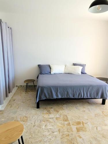 - une chambre avec un lit avec des draps bleus et une table dans l'établissement Studio agréable avec vue mer à Ajaccio - 30 m² avec accès plage, à Ajaccio