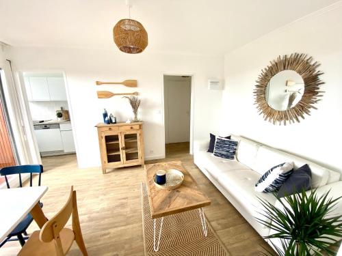 un salon avec un canapé blanc et une table dans l'établissement Cabourg-la plage à vos pieds, à Cabourg