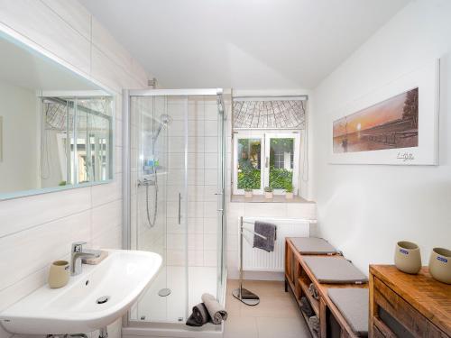 a white bathroom with a shower and a sink at City Appartements Arnstadt in Arnstadt