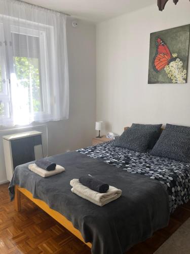 1 dormitorio con 1 cama con 2 toallas en Karman Apartman - 2 bedroom entire flat in the center, en Jászberény