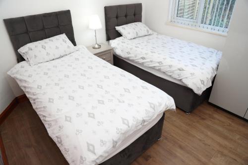 two twin beds in a room with at cosy 3-bed bungalow nec airport close to amenities in Birmingham