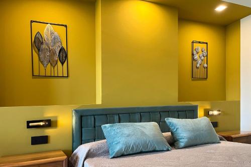 a bedroom with a blue bed with yellow walls at Continental Hotel in Lovere