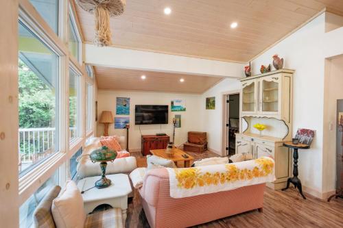 a living room filled with furniture and a large window at Sunflower Shores - South Bruce Peninsula - Bright Chalet on Lake Huron Once Upon A Stay in Wiarton