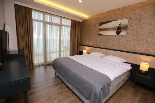 a bedroom with a large bed and a large window at PENTAHOR HOTEL in Giresun