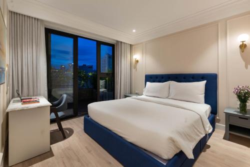 a bedroom with a bed and a desk and a window at Louis Mo Apartment in Da Nang