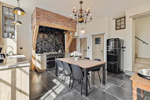 cocina con mesa, sillas y nevera en Huis Potaerde, stijlvol landhuis nabij Brussel voor 7 personen en Merchtem