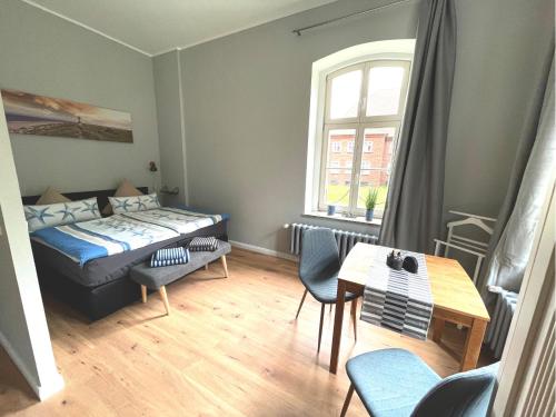 Habitación pequeña con cama, mesa y sillas en Gästehaus Sternschanze - App2 Kapitänleutnant en Stralsund