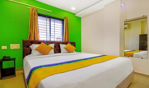 a bedroom with a large bed with a green wall at Itsy Hotels Carnival Inn in Nagpur