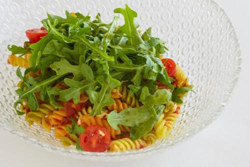 a glass bowl of pasta with lettuce and tomatoes at Torre del Marqués Hotel Spa & Winery - Small Luxury Hotels in Monroyo