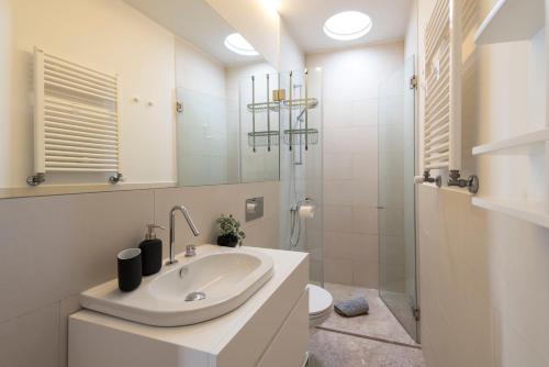 een witte badkamer met een wastafel en een douche bij Flores City Retreat in Porto