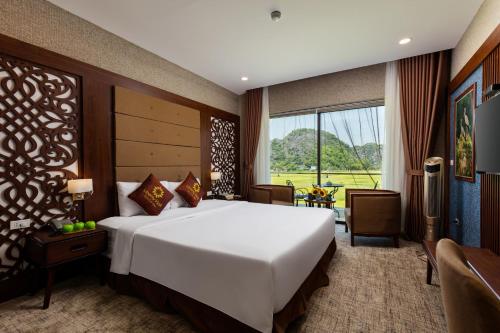 a bedroom with a large bed and a large window at Liberty Hall Tam Coc Hotel & Villa in Ninh Binh
