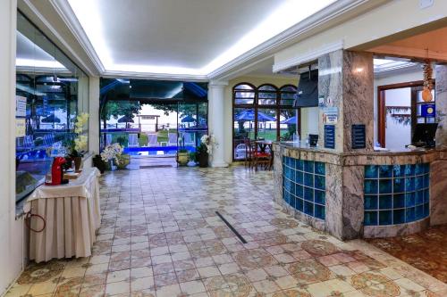 a lobby of a hotel with a bar in the middle at Indaiá Praia Hotel in Bertioga