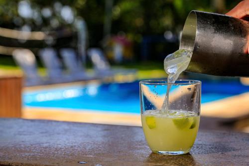 a drink is being poured into a glass on a table at Indaiá Praia Hotel in Bertioga