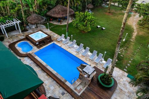 una vista aérea de una piscina con sillas y un patio en Indaiá Praia Hotel, en Bertioga