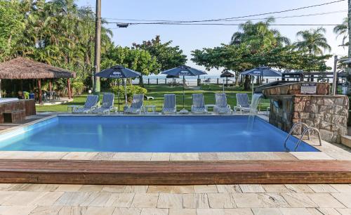 - une piscine avec des chaises et une table dans l'établissement Indaiá Praia Hotel, à Bertioga