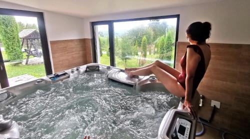 a woman is sitting in a hot tub at Alpina Panoramic in Moisei