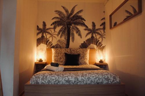 een slaapkamer met een bed met palmbomen aan de muur bij NEW Le Cocon Des Humanistes in Sélestat