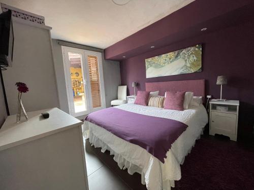 a bedroom with purple walls and a large bed at Los Veroles in Agaete