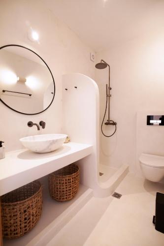 a white bathroom with a sink and a toilet at Villa Piccolo Mondo with private pool and sea view in Kalafatis