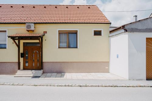 una casa bianca con una porta marrone di Apartment RADO 75m2 mit Garten und Terrasse a Winden am See