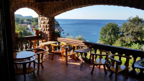 einen Balkon mit Tischen und Stühlen und Meerblick in der Unterkunft Villa Sara Guesthouse in Sveti Stefan