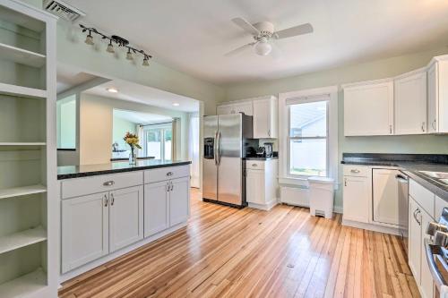 a kitchen with white cabinets and a refrigerator at Downtown Retreat with Grill, Fire Pit and Wet Bar in Lake George