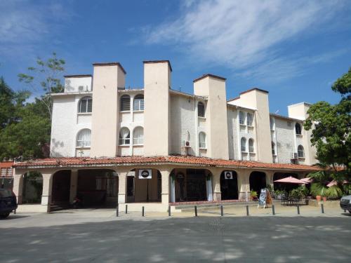 un gran edificio blanco sentado en la parte superior de una calle en Camino al Mar en Santa Cruz - Huatulco