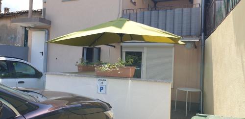 um guarda-chuva amarelo na lateral de um edifício em Apartment Laguna 79 em Izola