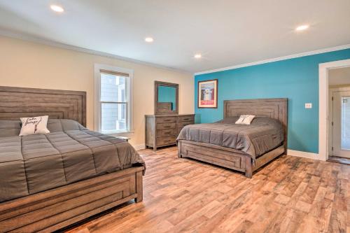 two beds in a bedroom with blue walls and wooden floors at Downtown Retreat with Grill, Fire Pit and Wet Bar in Lake George