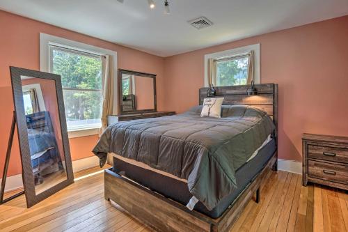 a bedroom with a large bed and a mirror at Downtown Retreat with Grill, Fire Pit and Wet Bar in Lake George
