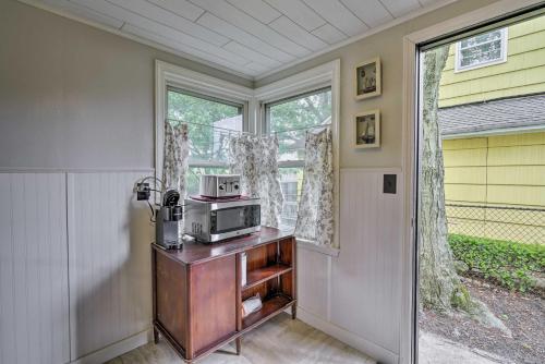 a kitchen with a microwave on a wooden cabinet next to a door at Point Pleasant Abode with Lagoon and Boat Dock! in Point Pleasant