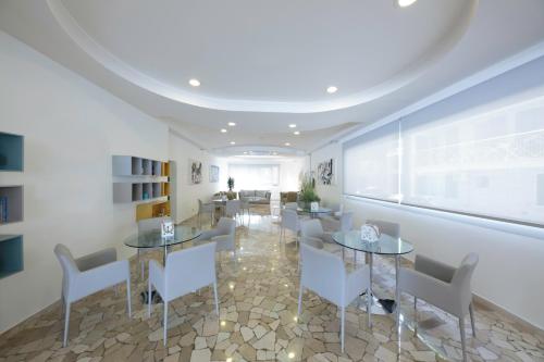 a dining room with tables and chairs and a window at Hotel Bristol in Caorle
