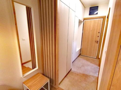 um corredor com uma porta e uma mesa num quarto em Apartman Kaya em Tivat