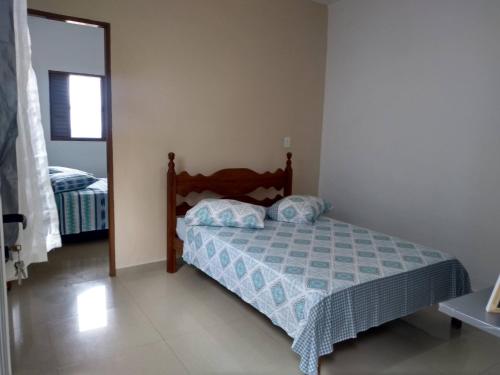 a small bedroom with a bed and a mirror at Casa da Montanha in São Thomé das Letras