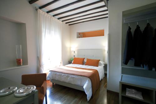 a bedroom with a bed with orange pillows and a window at Hotel Charleston in Spoleto