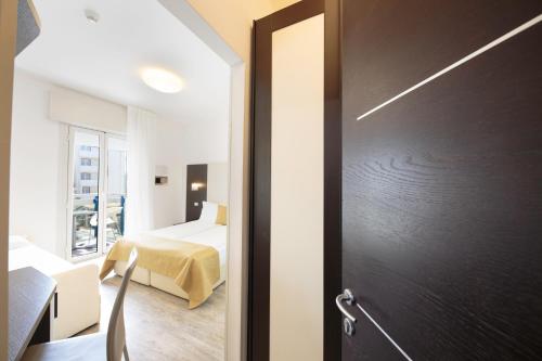 a door leading to a bedroom with a bed at Hotel Bristol in Caorle