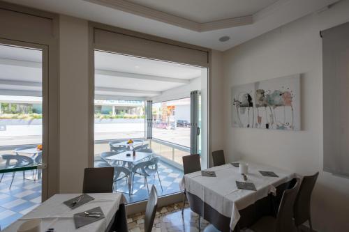 a dining room with two tables and a balcony at Hotel Bristol in Caorle