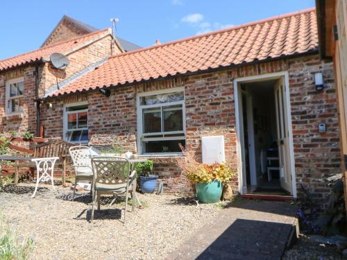 a brick cottage with a table and chairs in front of it at 3 Westgate Mews in Ripon