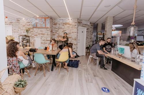 a group of people sitting at tables in a room at We Hostel Palma - Albergue Turístico in Palma de Mallorca
